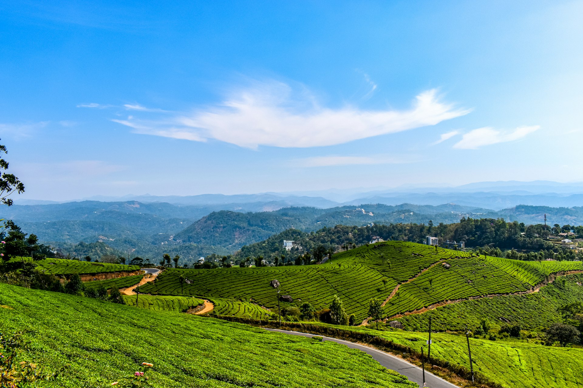 green grass field near mountain under blue sky during daytime